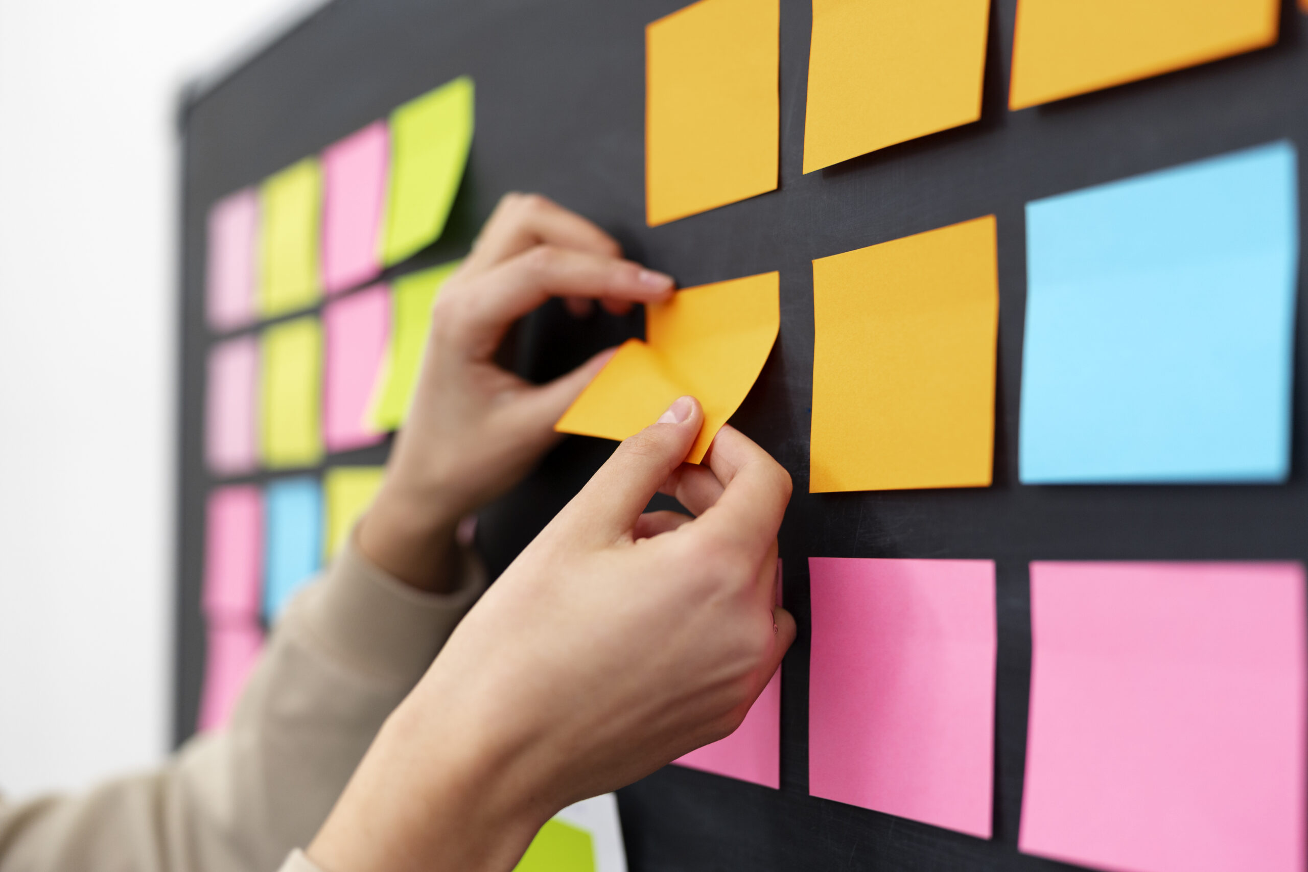 side-view-hands-sticking-yellow-post-it